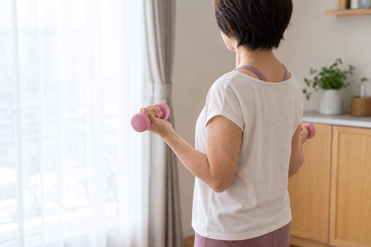 ダンベルを持つ女性（自宅トレーニング）